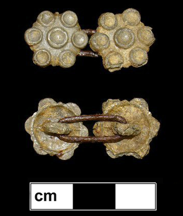 Cast pewter buttons with a copper alloy link. The motif of six circles around a center circle gives the appearance of being a setting for jewels, though it clearly was not designed to have any. 